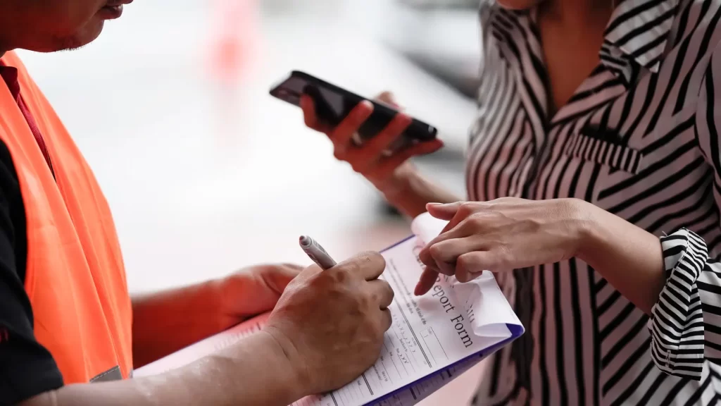 a person is signing a form for injury claims compensation after an accident