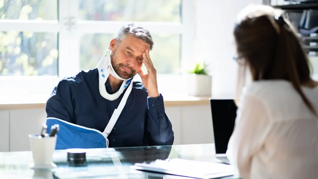 a man with a neck brace lost future earnings after an accident and sitting at a table with a woman