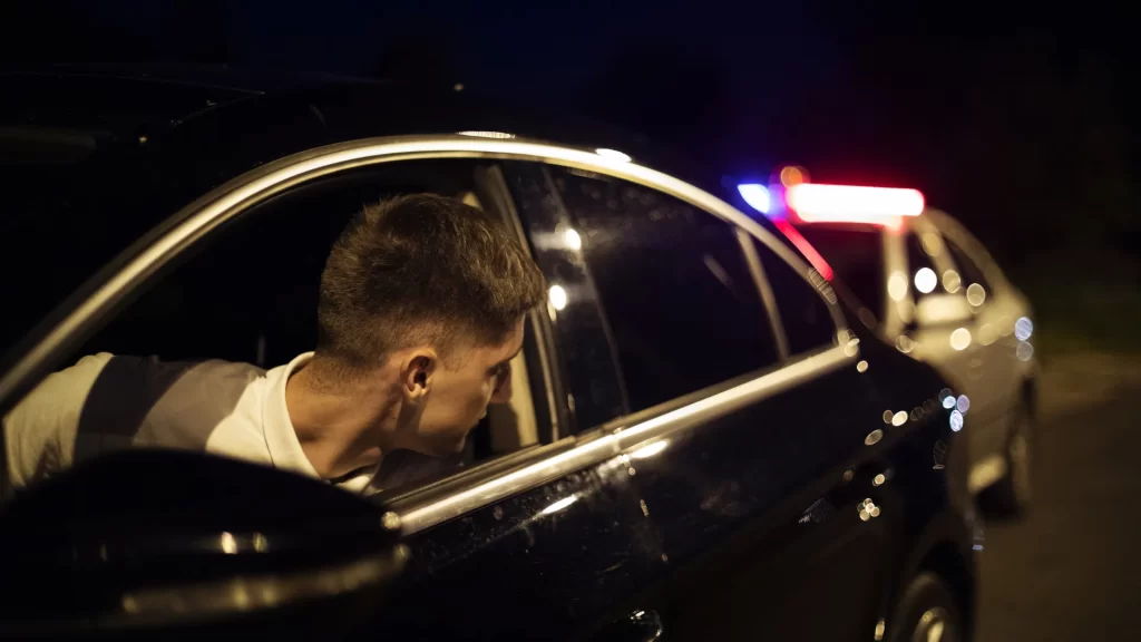 a man looking out of a car window at night after a car accident