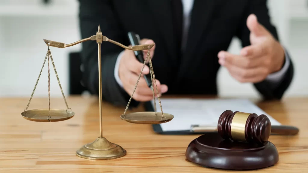 a personal injury attorney holding a pen over a scale