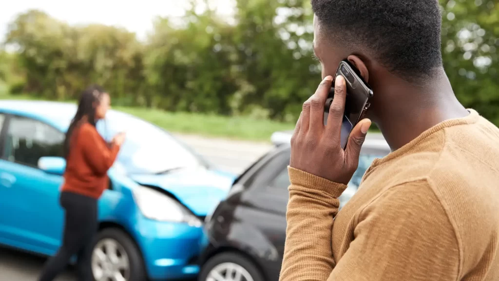 a man talking on a cell phone reporting the car crash